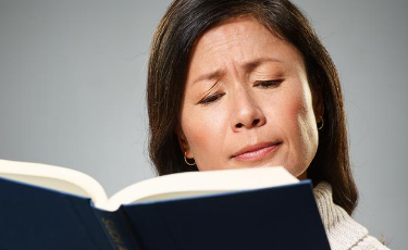 Woman squinting While Reading a Book