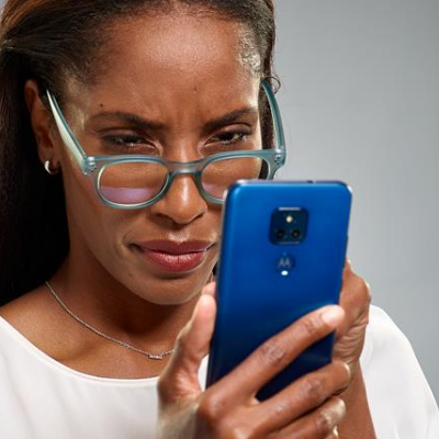 Woman with Glasses Concentrating on Phone